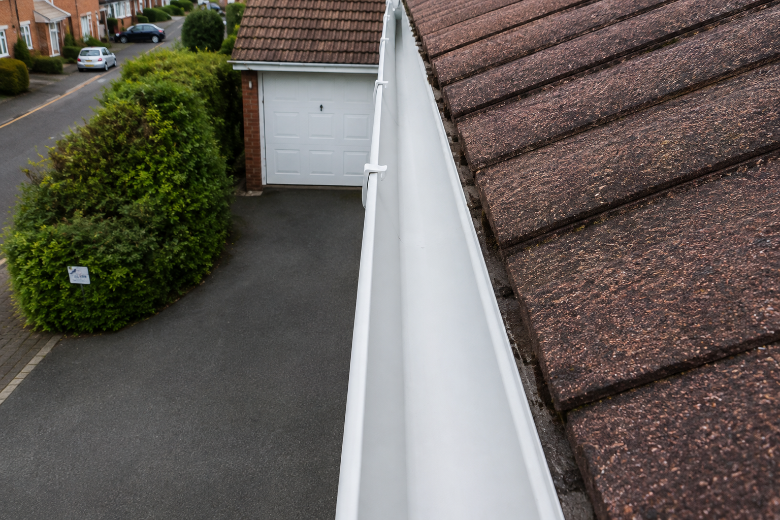 Gutter fully cleared of moss-derived debris after professional cleaning — moss removed from the roof source and the channel cleared to the floor